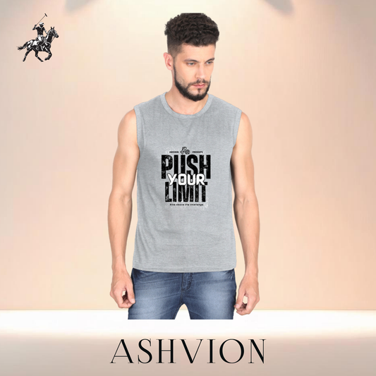 Man wearing a sleeveless shirt with motivational text and jeans, standing against a beige background with 'ASHVION' branding.