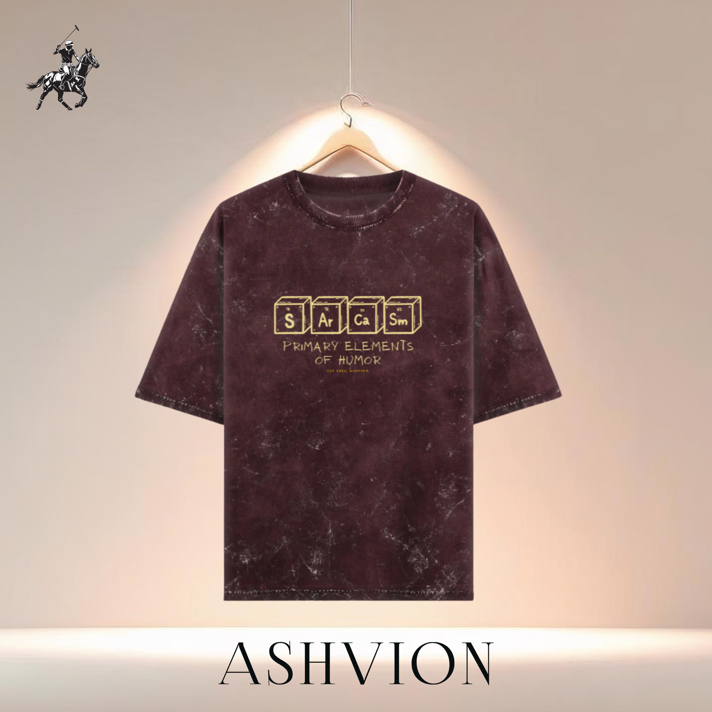 Maroon t-shirt with gold text on a hanger against a neutral background, featuring the brand 'ASHVION'.