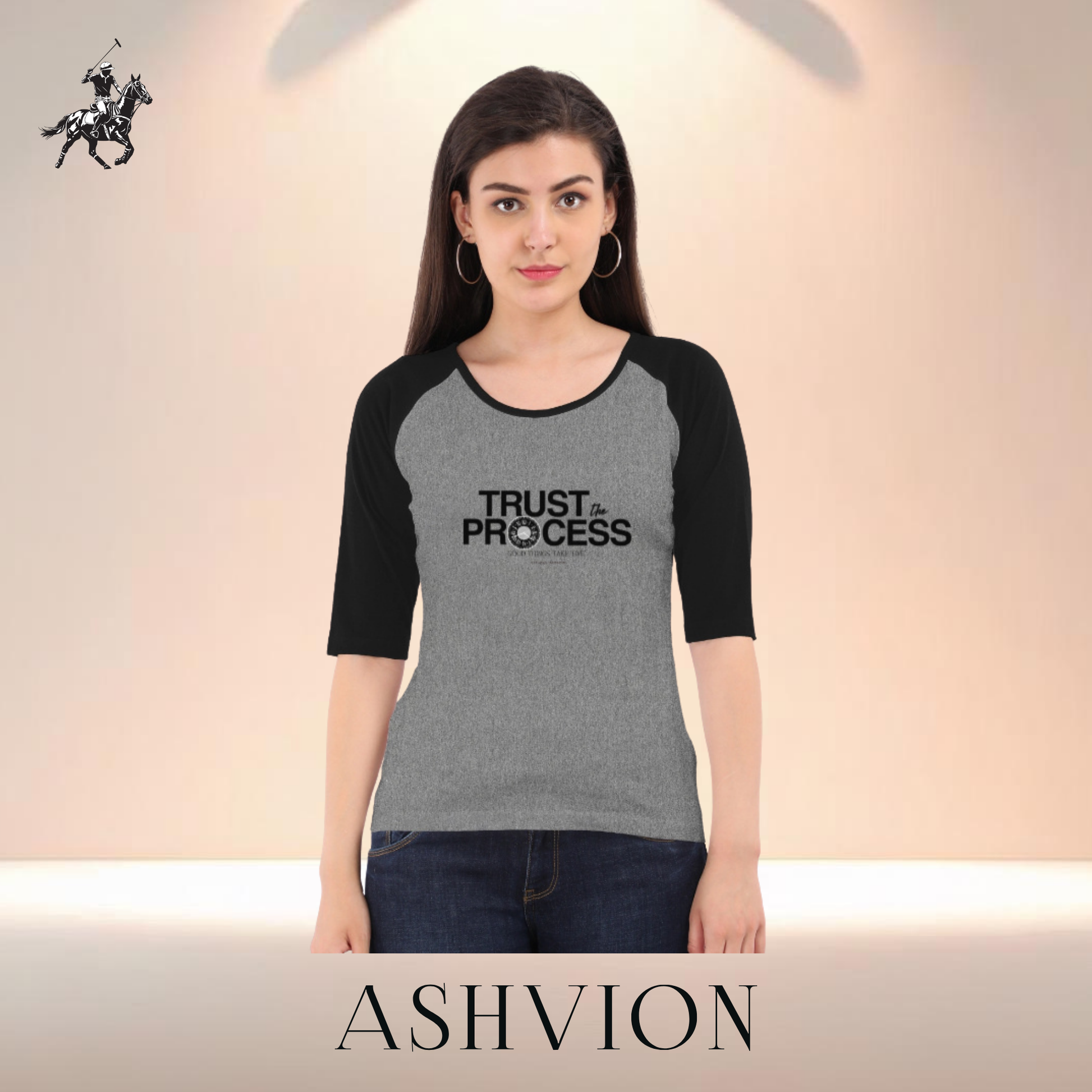 Woman wearing a gray and black t-shirt with 'Trust the Process' text, standing against a plain background with 'ASHVION' branding.